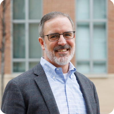 man with glasses looking at camera smiling